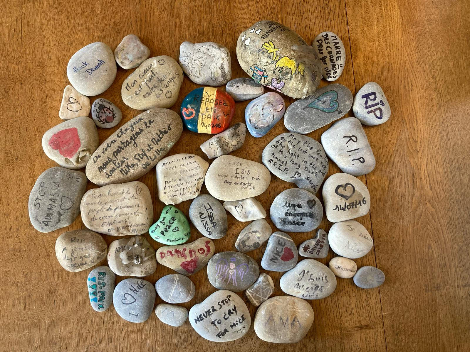 photographie de galets peints en hommage aux victimes de l'attentat du 14 juillet 2016 à Nice